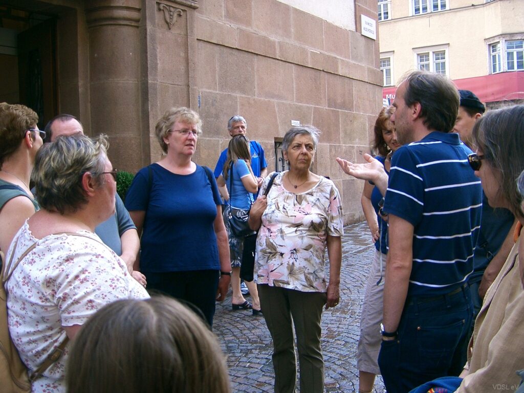 Eine Gruppe von Menschen versammelt sich für eine Stadtführung in einer historischen Umgebung.