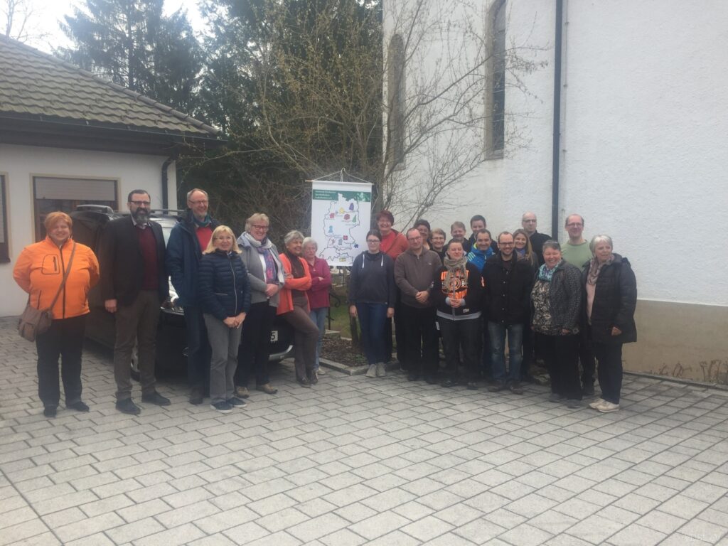 Gruppenfoto von Teilnehmern eines Symposiums vor einem Gebäude im Freien.
