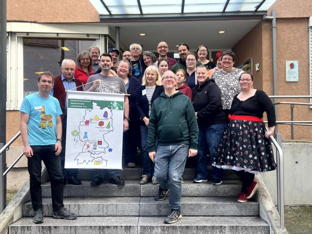 Eine Gruppe von Menschen steht auf einer Treppe vor einem Gebäude mit einer Karte von Deutschland.